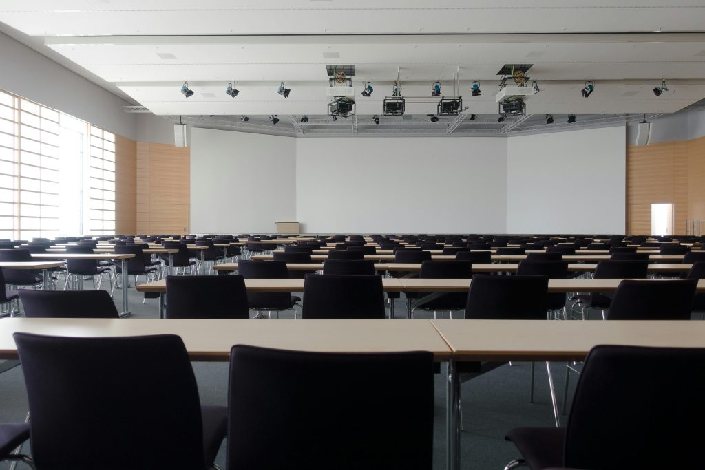 Spacious lecture theatre featuring integrated ceiling lights and electrical infrastructure, highlighting the role of electricians in creating well-lit learning environments.